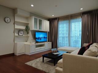 Modern living room with entertainment center, large window, and cozy seating