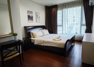 Spacious bedroom with large window and modern furnishings