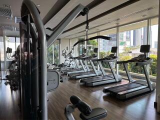 Modern fitness center with exercise equipment and large windows