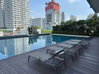 Modern outdoor pool with lounge chairs and city skyline view