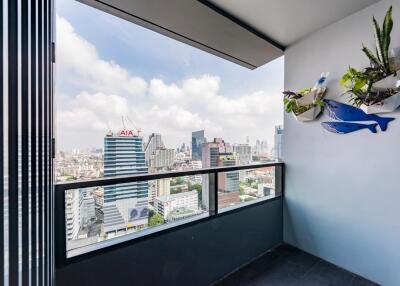 City view from the balcony with decorative wall plants and clear railing