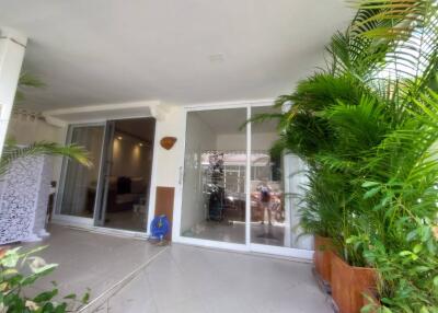 Main entrance with glass doors and surrounding greenery