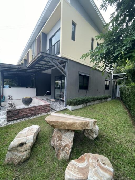 Exterior view of a modern two-story house with patio and garden