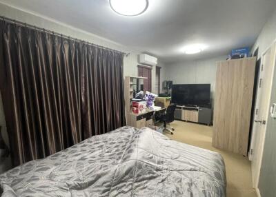 Bedroom with a bed, curtains, air conditioning, desk, chair, television, and wardrobe