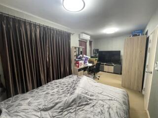 Bedroom with a bed, curtains, air conditioning, desk, chair, television, and wardrobe