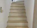 Indoor staircase with light wood steps and white walls