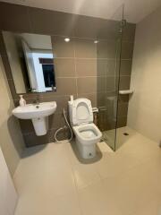 Modern bathroom with a glass-enclosed shower, toilet, and sink