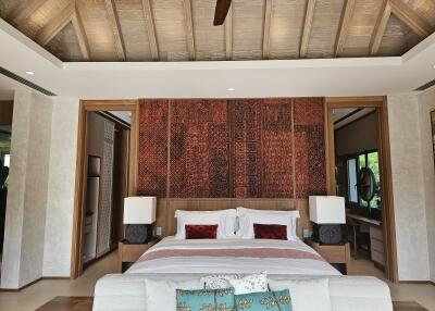 Spacious bedroom with wooden ceiling and decorative wall panel