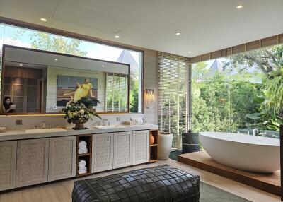 Luxurious bathroom with large mirror, bathtub, and lush garden view