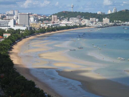 Scenic view of a beach with buildings and hills in the background