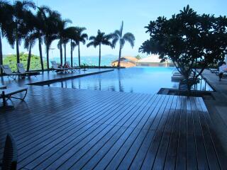 Swimming pool with poolside seating and palm trees