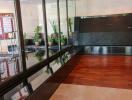 Lobby area with wood and tile flooring, glass walls, and potted plants