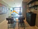 Dining area with table and chairs, shelves on the wall, a painting, and neutral-tone decor