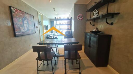 Dining area with table and chairs, shelves on the wall, a painting, and neutral-tone decor