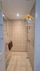 Modern bathroom with tiled walls and glass shower enclosure