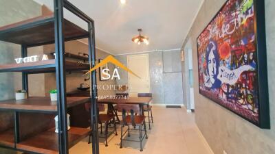 Modern dining area with industrial-style shelving and artwork