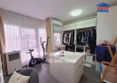 Bedroom with closet, exercise bike, and large windows