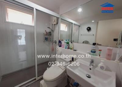 Modern bathroom with glass shower, sink, and toilet