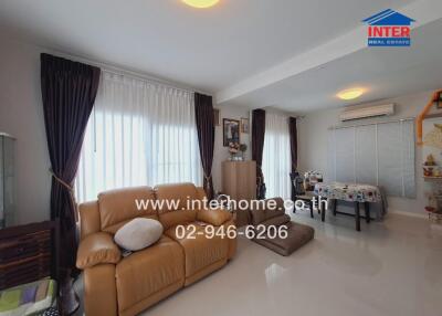 Living room with beige sofa, window curtains, dining table, and air conditioner