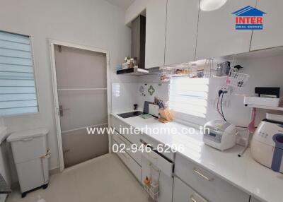 Modern kitchen with white cabinetry, appliances, and ample counter space