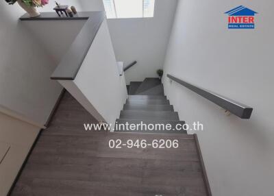 Interior view of a staircase from above with wooden flooring and handrails