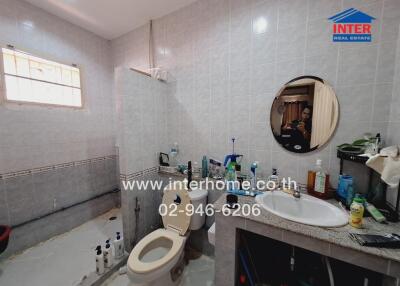 Bathroom with light-colored tiles and various toiletries