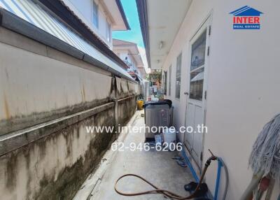 Narrow outdoor utility area with washing machine