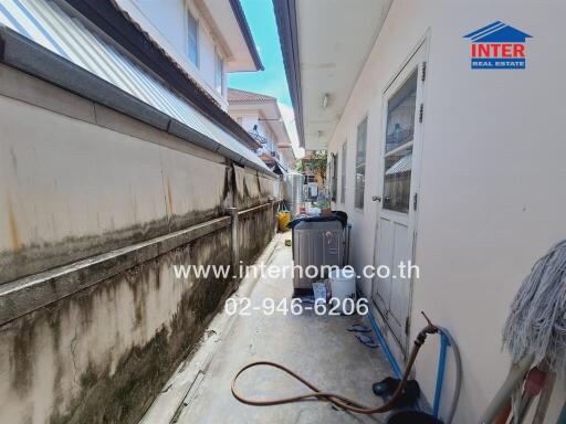 Narrow outdoor utility area with washing machine