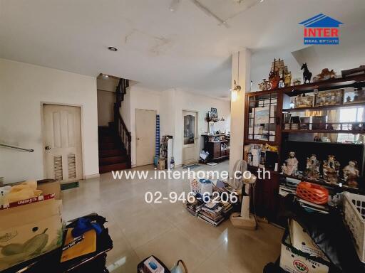 Living room with staircase and various storage items