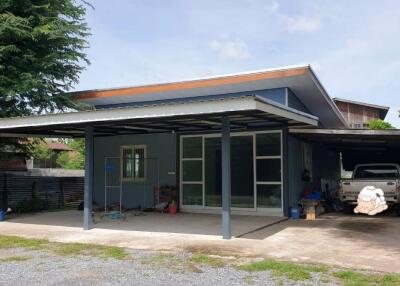 Modern house exterior with large windows and carport