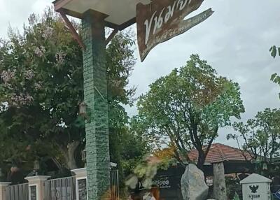 Entrance to property with sign and greenery