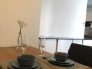 Dining area setup with tableware and flower vase