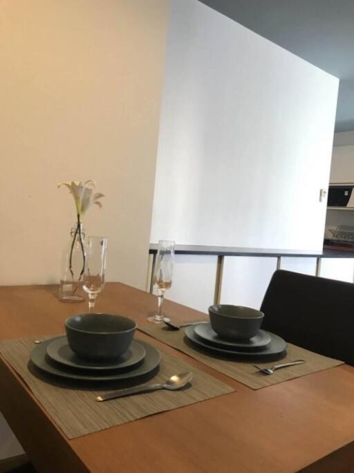 Dining area setup with tableware and flower vase