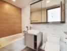 Modern bathroom with bathtub, toilet, and sink.