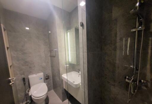 Modern bathroom with glass shower, white toilet, and sink