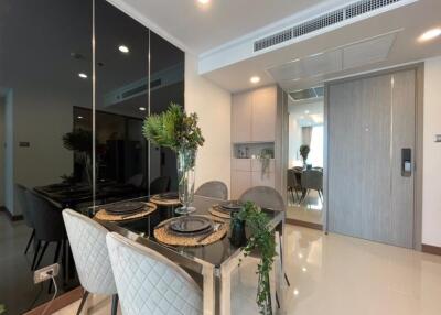 Modern dining area with glass table and gray upholstered chairs