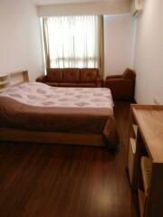 Bedroom with bed, sofa, and wooden flooring