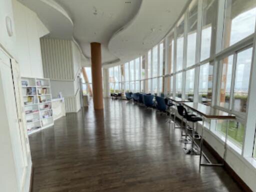 spacious hallway with large windows and seating area