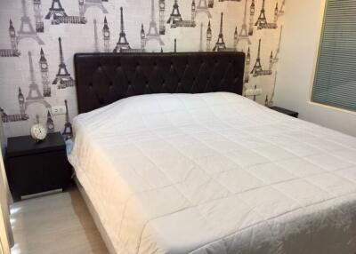 Bedroom with Eiffel Tower themed wallpaper and a large bed