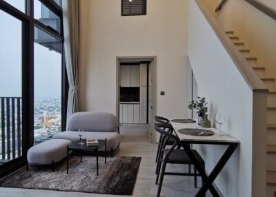 Modern living area with high ceiling and staircase