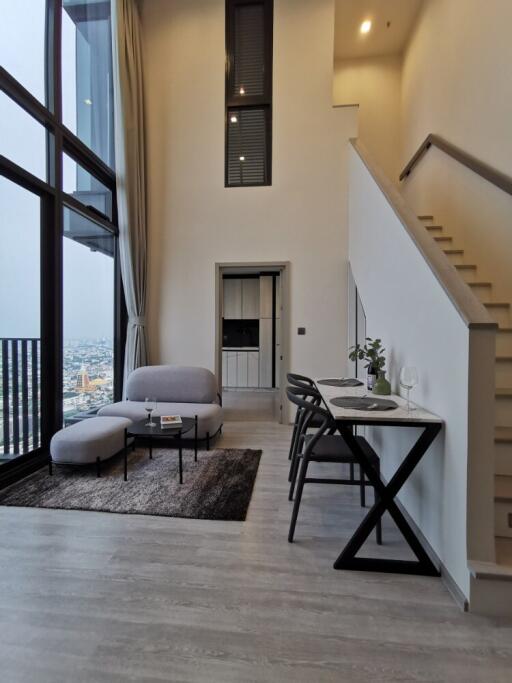 Modern living area with high ceiling and staircase