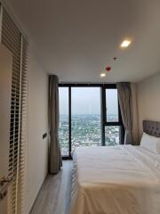 Modern bedroom with large windows and city view