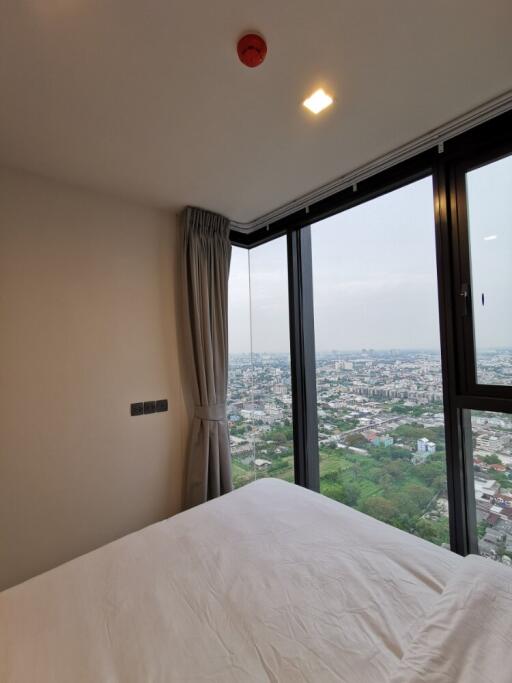 Bedroom with large windows and scenic city view