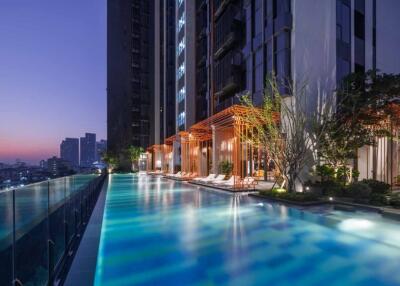 Outdoor pool and modern high-rise building at sunset