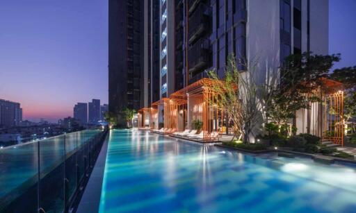 Outdoor pool and modern high-rise building at sunset