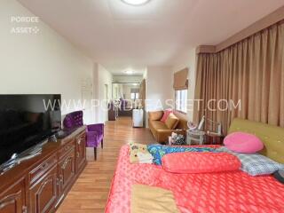 Bedroom with a bed, a TV, a sofa, and assorted furniture