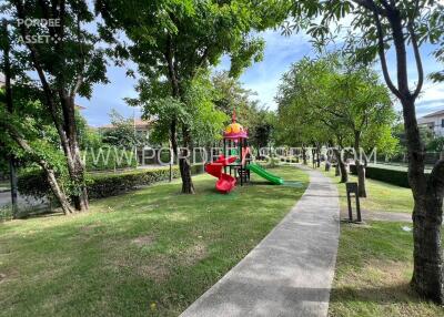 Outdoor playground area with slide and greenery