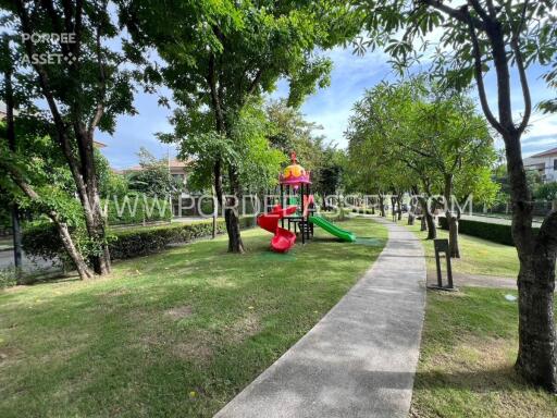 Outdoor playground area with slide and greenery