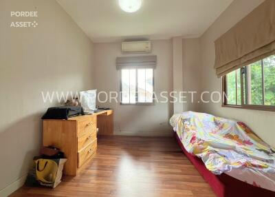 Bedroom with wooden flooring, desk, chair, bed, and a window