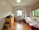 Bedroom with wooden flooring, desk, chair, bed, and a window